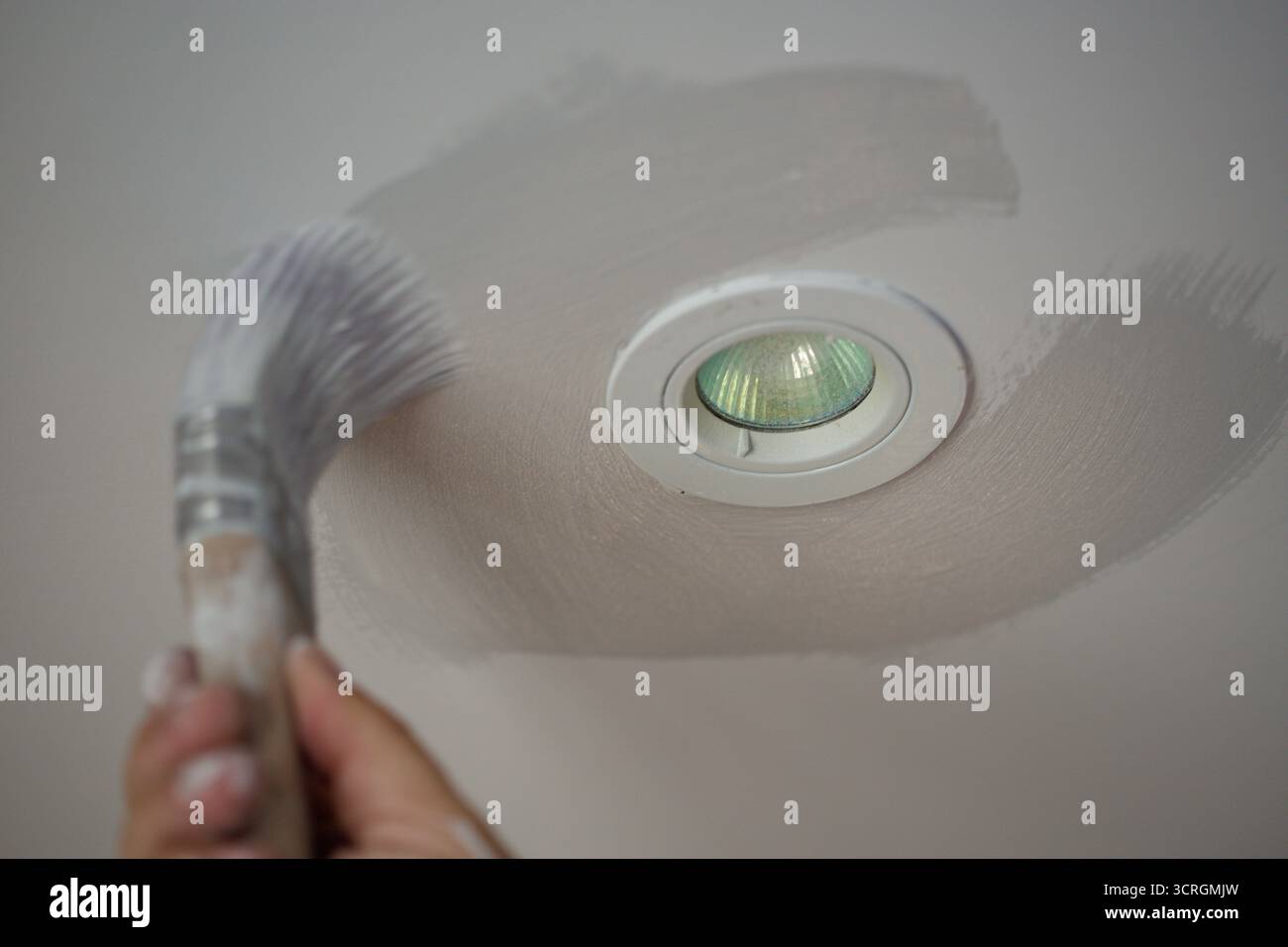 Einfahren. So nennen Dekorateure das anfängliche Bemalen um Objekte und Kanten, bevor sie Farbe mit einer Rolle oder einem Spray auftragen. Stockfoto