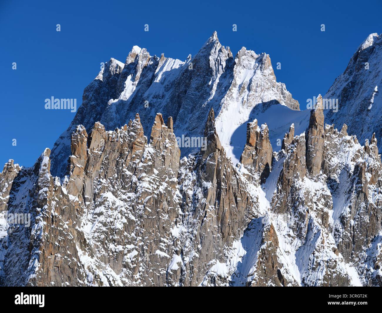LUFTAUFNAHME. Die Périades: Eine Felsformation aus vielen Granitspitzen, Grandes Jorasses (4208 m) in der Ferne. Chamonix-Mont-Blanc, Frankreich. Stockfoto