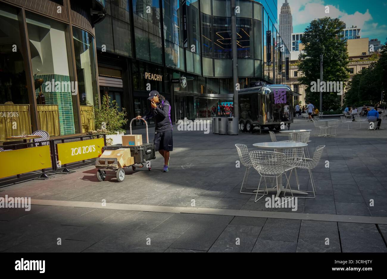 FedEx-Arbeiter, seine Wagen voll mit Paketen, geht am Freitag, den 26. September 2025, auf seine ernannten Runden in der Manhattan West-Entwicklung in New York. (© Richard B. Levine) Stockfoto