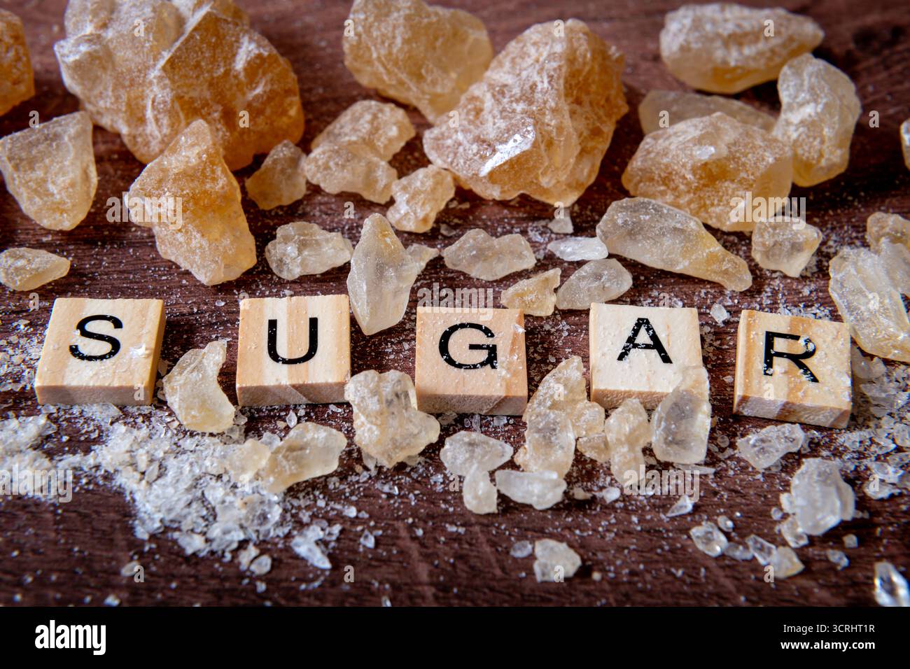 Eine Nahaufnahme des Wortes Zucker umgeben von Steinzucker in verschiedenen Größen und Formen. Stockfoto