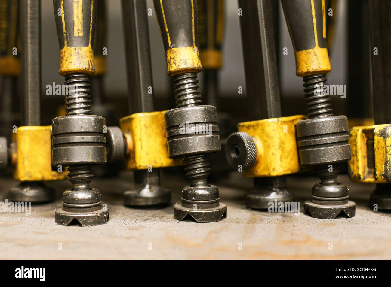 Schweißklemmen in der Werkstatt. Industrielle Metallwerkzeuge Nahaufnahme. Hintergrund für Hochleistungs-Baumaschinen. Maschinenbauobjekte für die Arbeit. Stockfoto