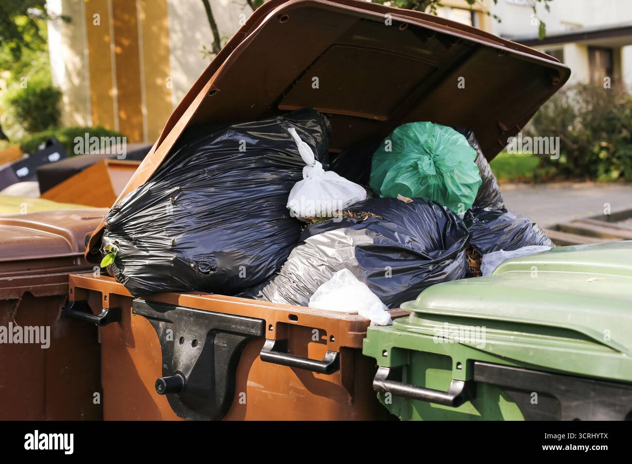Müllcontainer voll Müllbeutel. Details zur Abfallentsorgung im Außenbereich. Umweltproblem mit Müllüberlauf. Stadtverschmutzung mit Plastik. Stockfoto