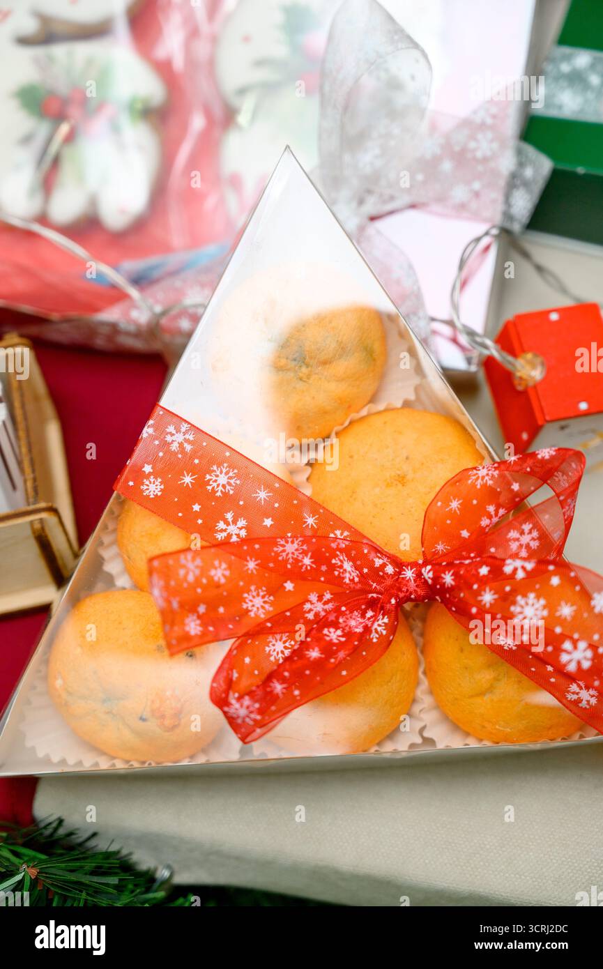 Neujahrsgeschenkidee: Mandarinen in kreativer Verpackung. Weihnachtsmandarinen in einer Geschenkbox. Helle Zitrusfrüchte in transparenter Verpackung mit einem roten B Stockfoto