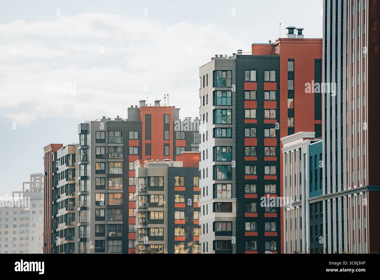 Neue Hochhäuser mit moderner Architektur und vielfältigen Materialien spiegeln urbanes Leben, Entwicklung und die Erweiterung der Skyline der Stadt unter hellem Himmel wider Stockfoto