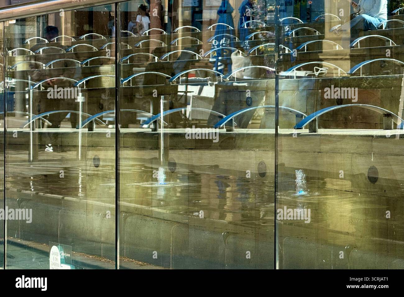 Reflexionen in Glas vor dem Sitzbereich am Exchange Square im Stadtzentrum von Manchester Stockfoto
