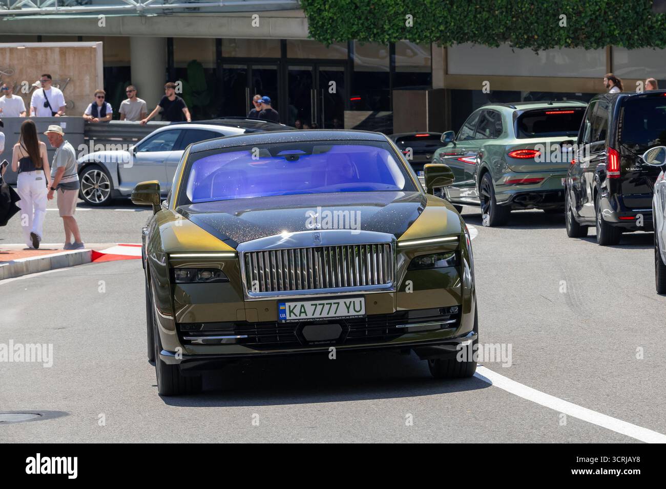 Monte Carlo, Monaco – Blick auf einen gelb-schwarzen Rolls-Royce Spectre, der auf der Straße in der Fairmont-Haarnadelkurve fährt. Stockfoto