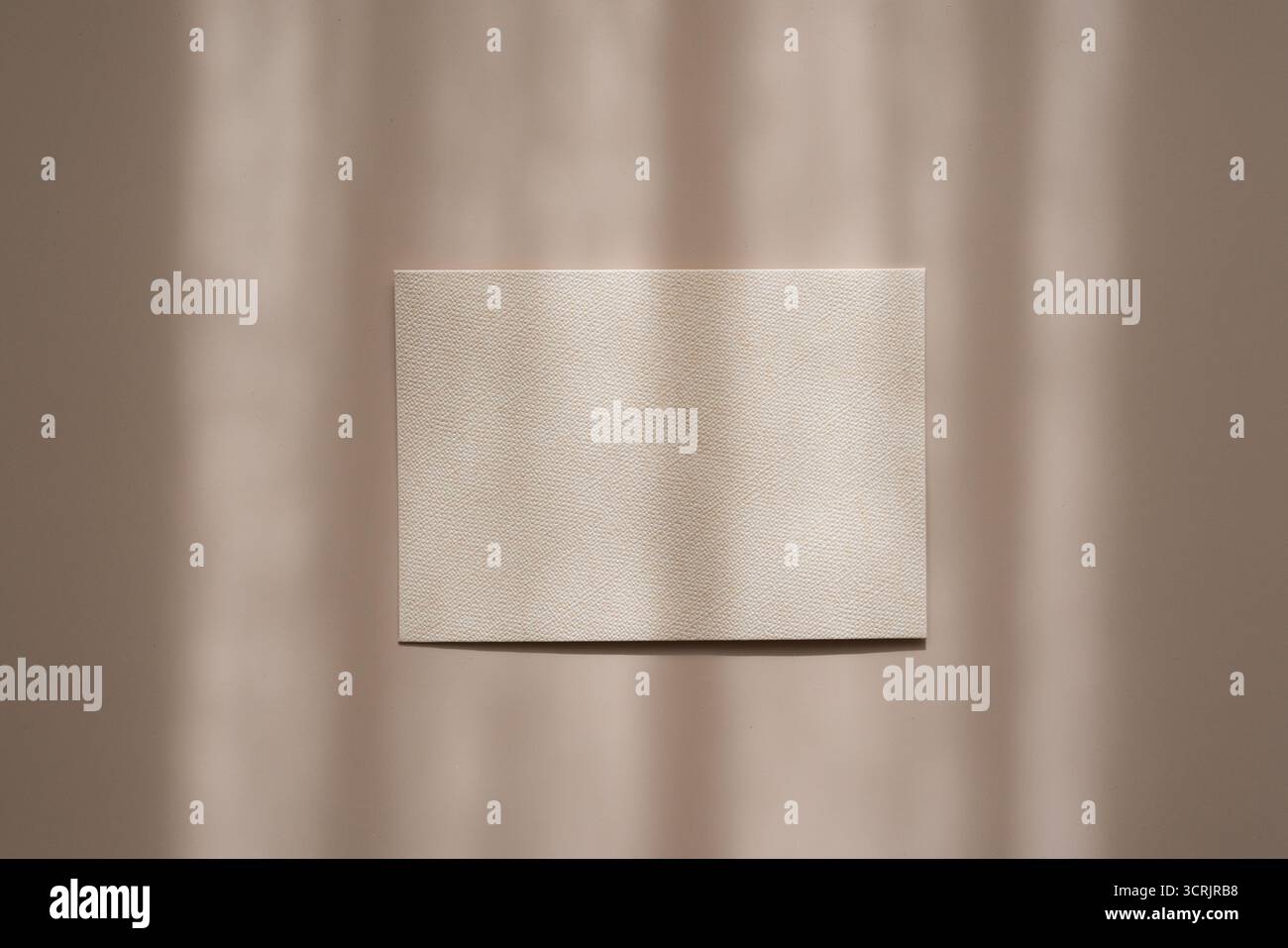 Weiße Papier-leere Karte auf beigefarbenem Hintergrund mit weichen Schatten, flache Lagen-Ästhetik. Einladung, Grußkarte nachgeahmt Stockfoto