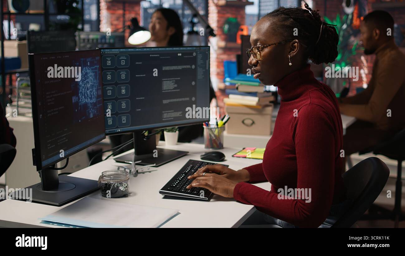 IT-Startup-Mitarbeiter verwenden eine Anwendung mit großem Sprachmodell, um Hilfe bei Programmieraufgaben zu erhalten. Frau interagiert mit KI LLM Chatbot PC GPT Software auf PC in Software-Entwicklung Arbeitsplatz, Kamera A Stockfoto