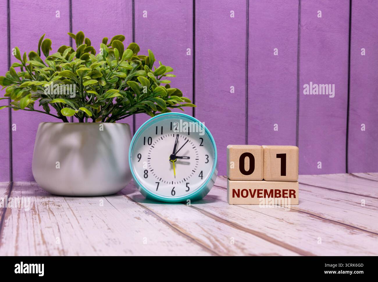 November. Bild des hölzernen Farbkalenders vom 1. november auf weißem Backsteinmauerhintergrund. Leeres Leerzeichen für Text. Stockfoto