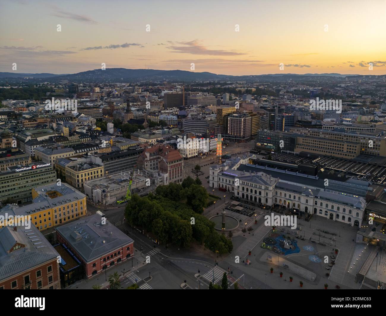 Aus der Vogelperspektive des Nationaltheaters, das lange Schatten in der späten Tagessonne wirft, seine neoklassizistische Fassade glänzt vor der Stadtlandschaft, Oslo, Norwegen. Stockfoto