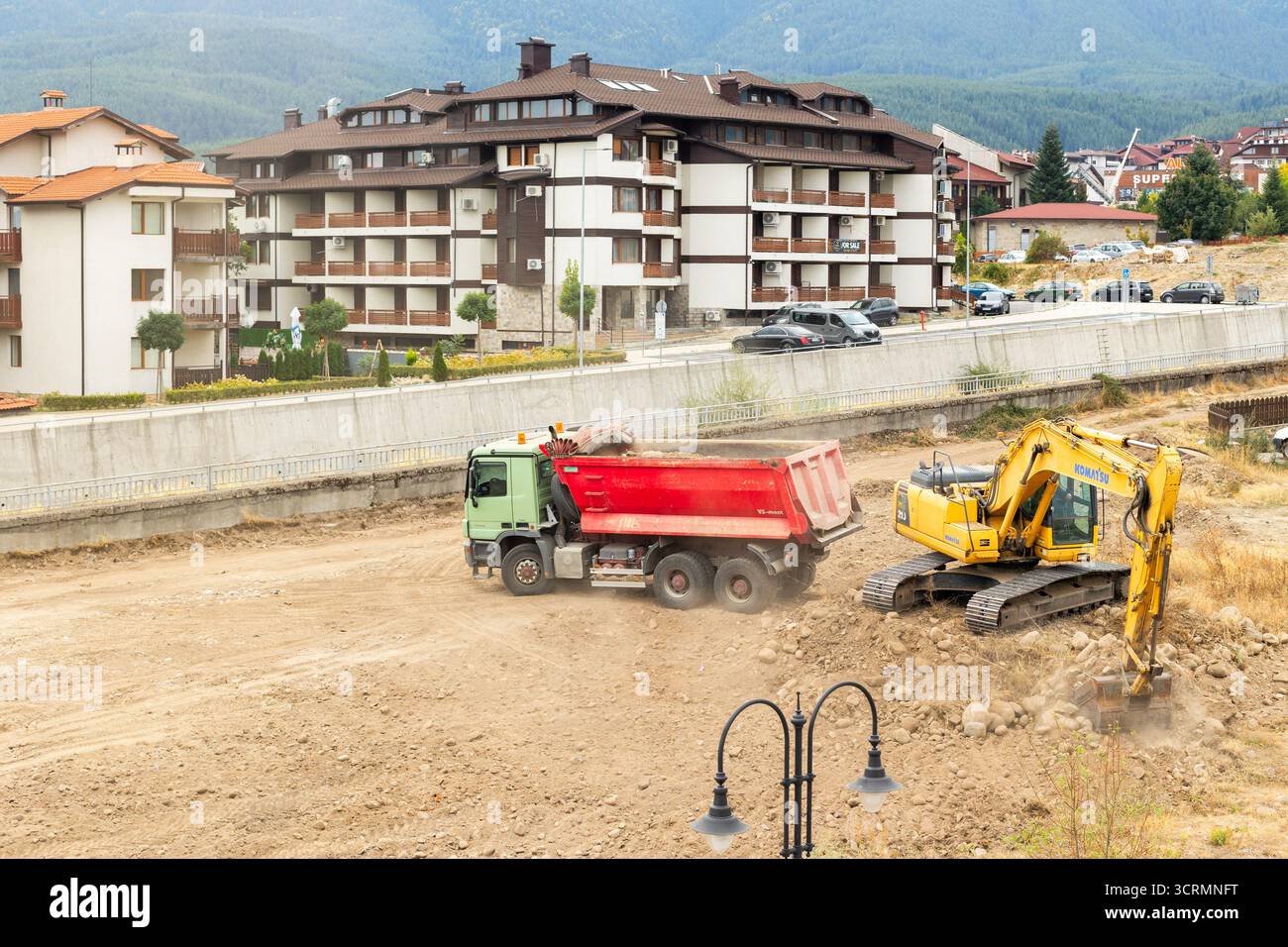 Bansko, Bulgarien - 25. September 2025: Industriegutmaschine lädt Boden in einen Kipper Stockfoto