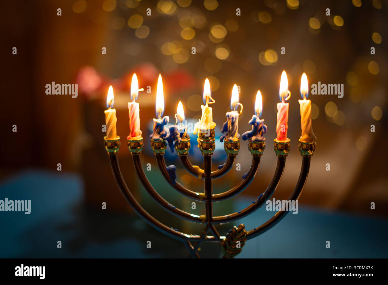 Eine Menora mit neun zündeten Kerzen vor einem sanften, leuchtenden Bokeh-Hintergrund, die Wärme und Frieden zur Feier von Hanukka weckt. Selektiver Fokus. Stockfoto