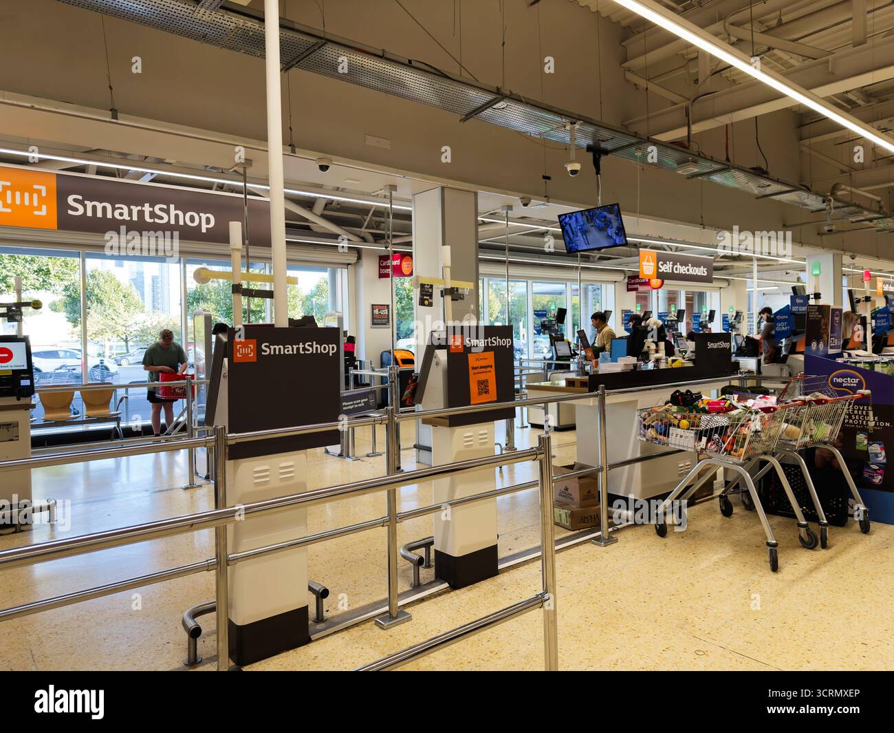 Salford, Großbritannien - 25. September 2025: Helle Szene an einem Salford Sainsbury's Supermarkt-Checkout mit Self-Service und geschäftigen Einkäufern. Stockfoto