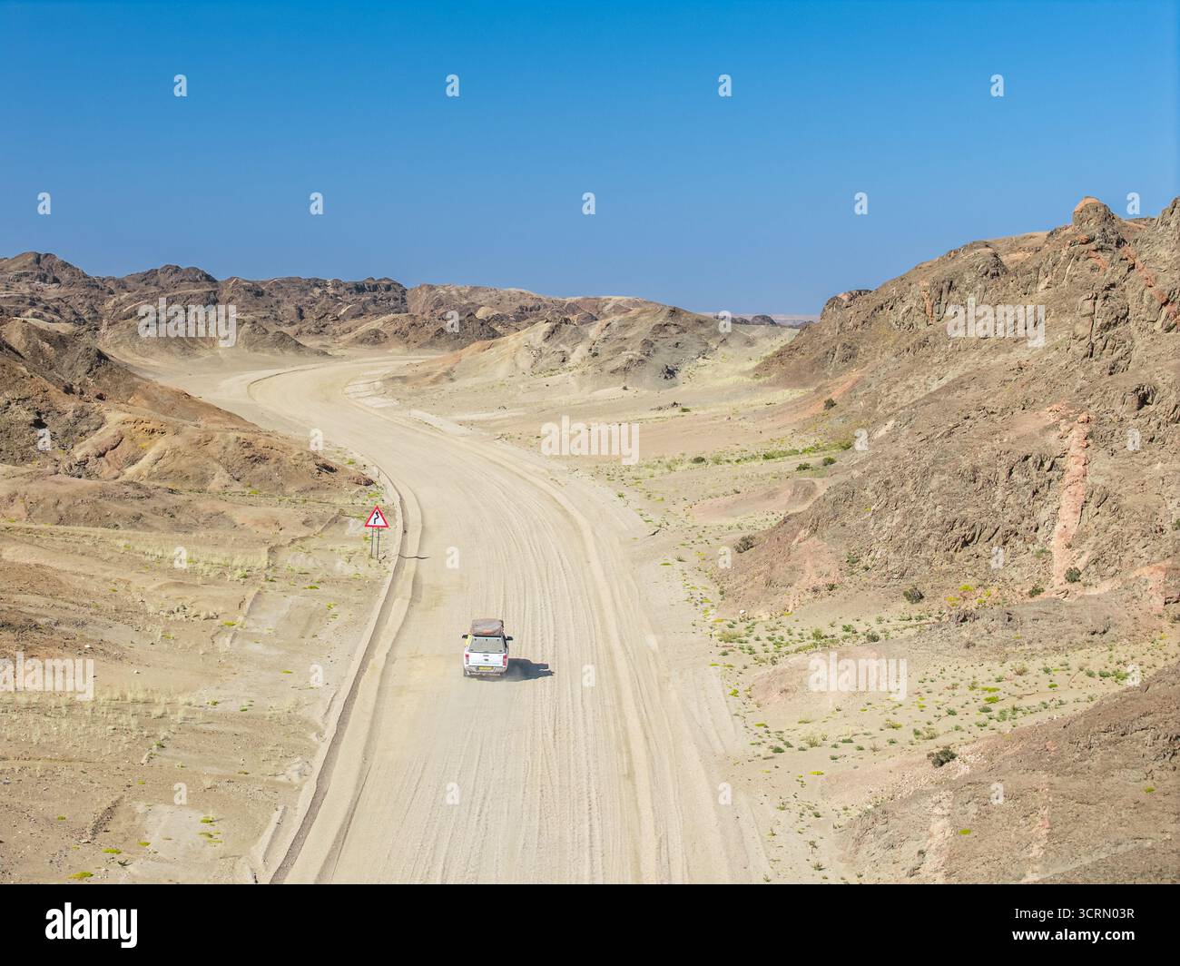 Schotterstraße schlängelt sich durch den felsigen Canyon des Mondlandes (Mondlandschaft), Swakopmund, Namibia. Stockfoto