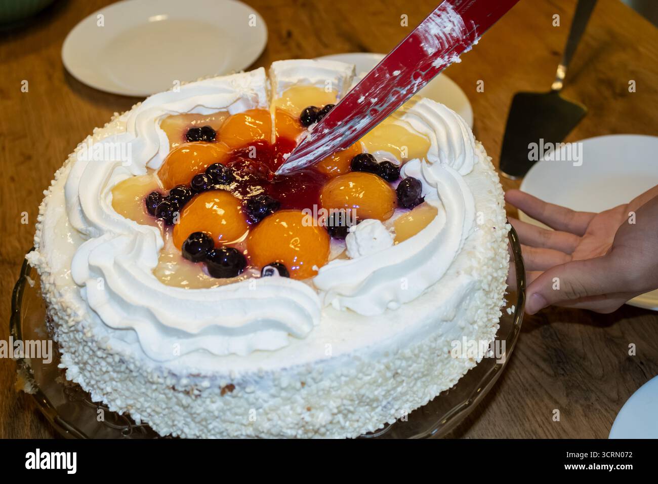 Obstkuchen mit Glasur schneiden Stockfoto