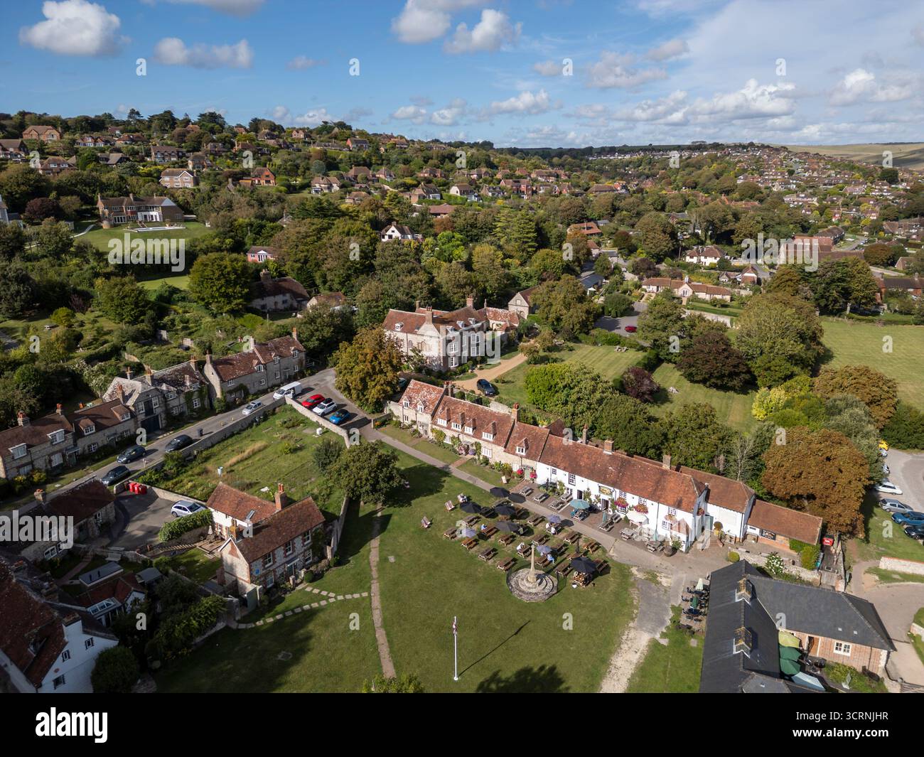 EAST DEAN, EAST SUSSEX, ENGLAND - 8. SEPTEMBER 2025: Aus der Vogelperspektive auf das East Dean Village Green in East Sussex, England, traditionelle Dorfgebäude in East Sussex Stockfoto