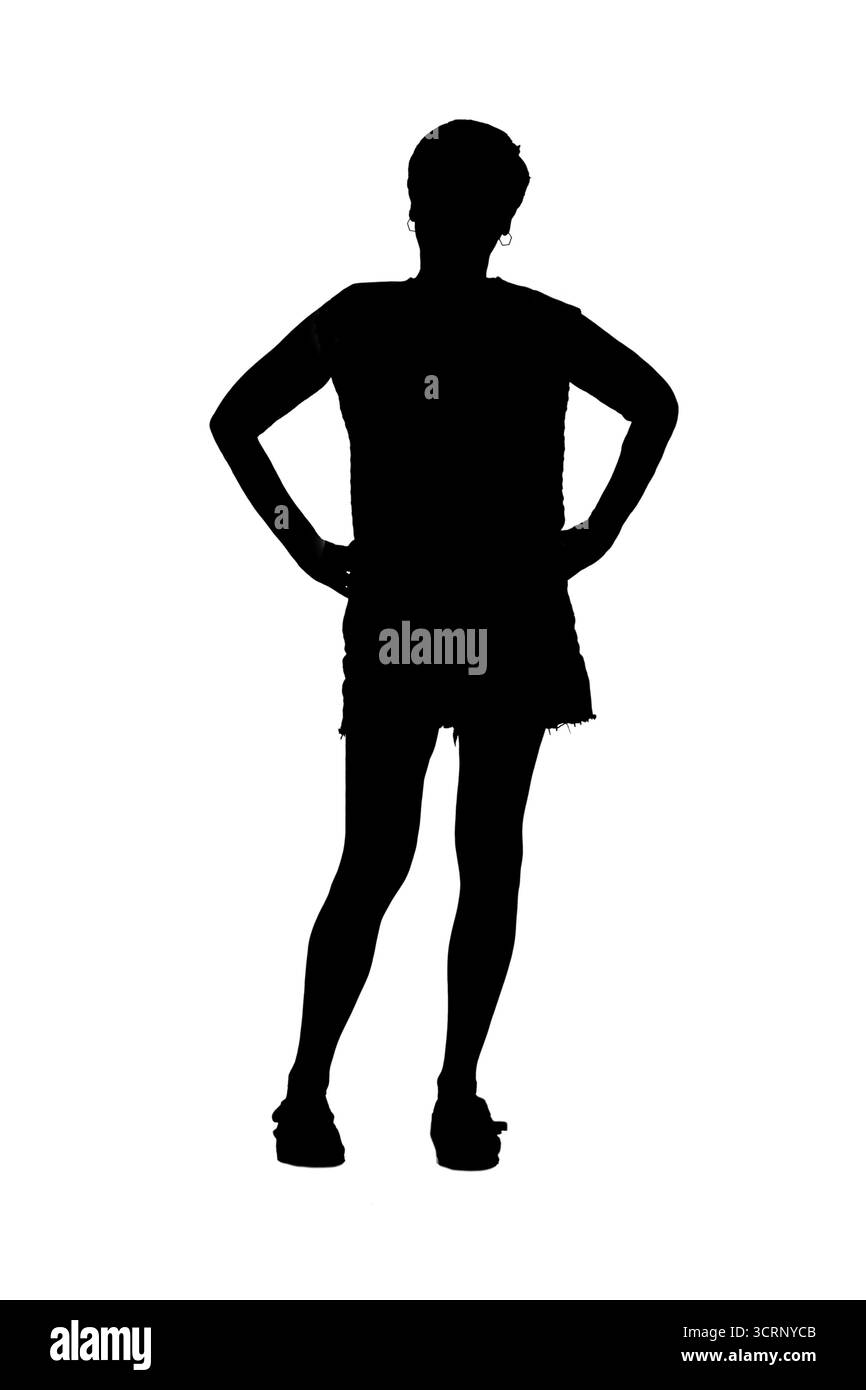 Silhouette der Vorderansicht eines vollständigen Porträts einer erwachsenen Frau mit Blick auf Kamera und Arme akimbo Stockfoto