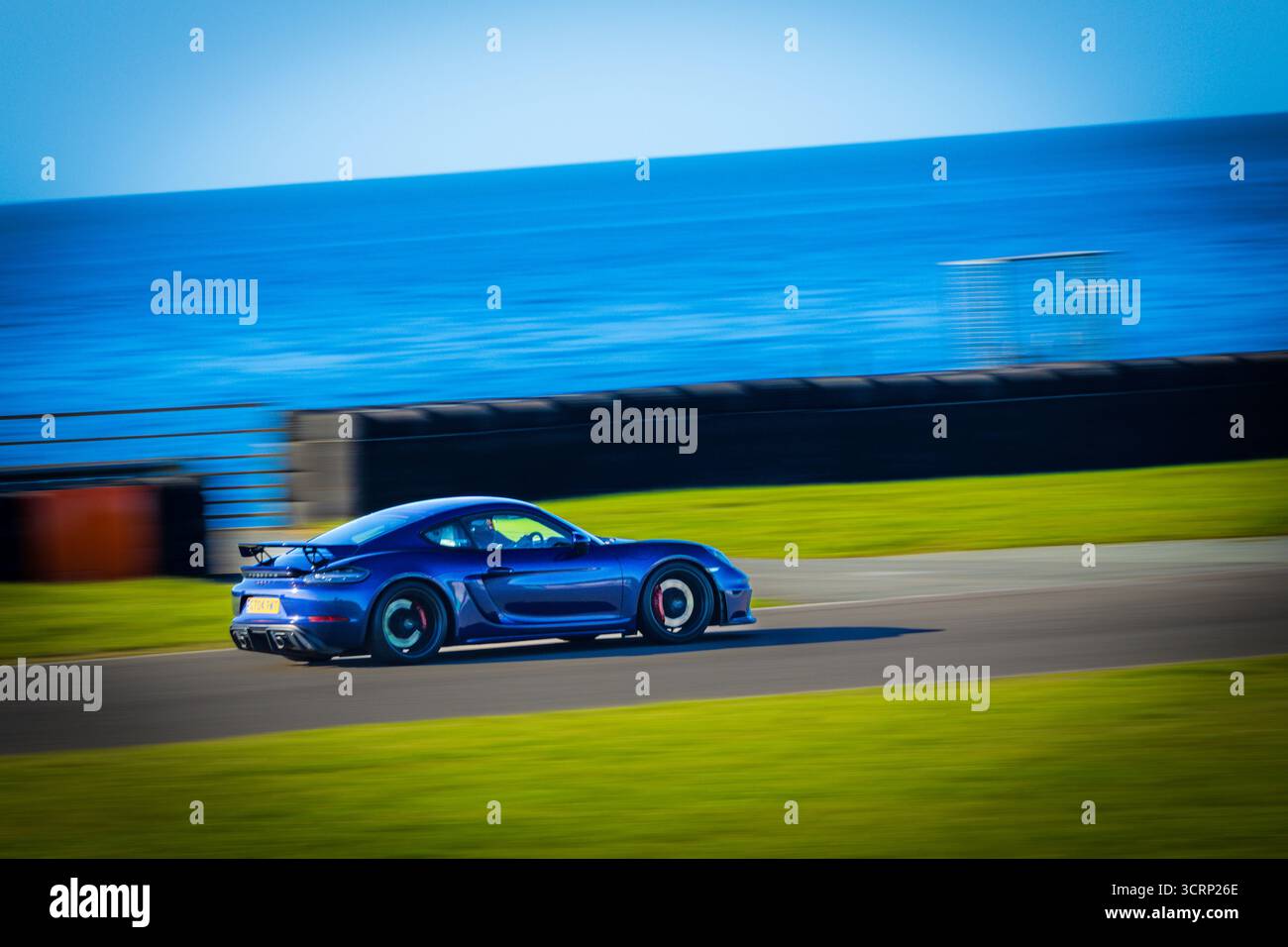Blauer Porsche-Sportwagen auf der Rennstrecke von Anglesey während des Mission Motorsport Track Day, sonnigem September Event, Geschwindigkeit und Leistung des britischen Motorsports Stockfoto