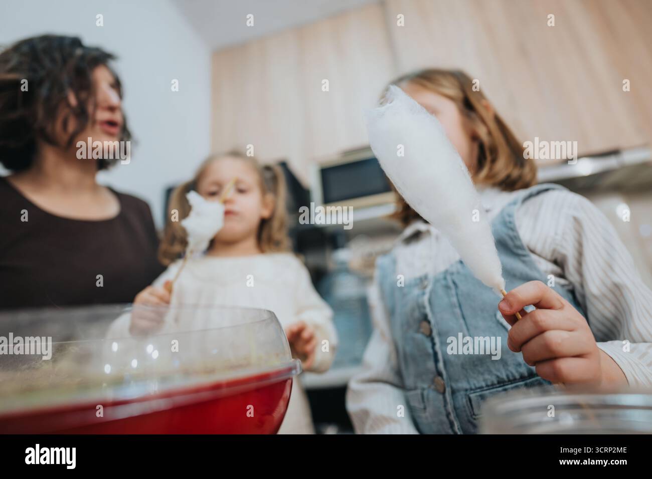Mutter und Töchter genießen hausgemachte Zuckerwatte in ihrer Küche Stockfoto