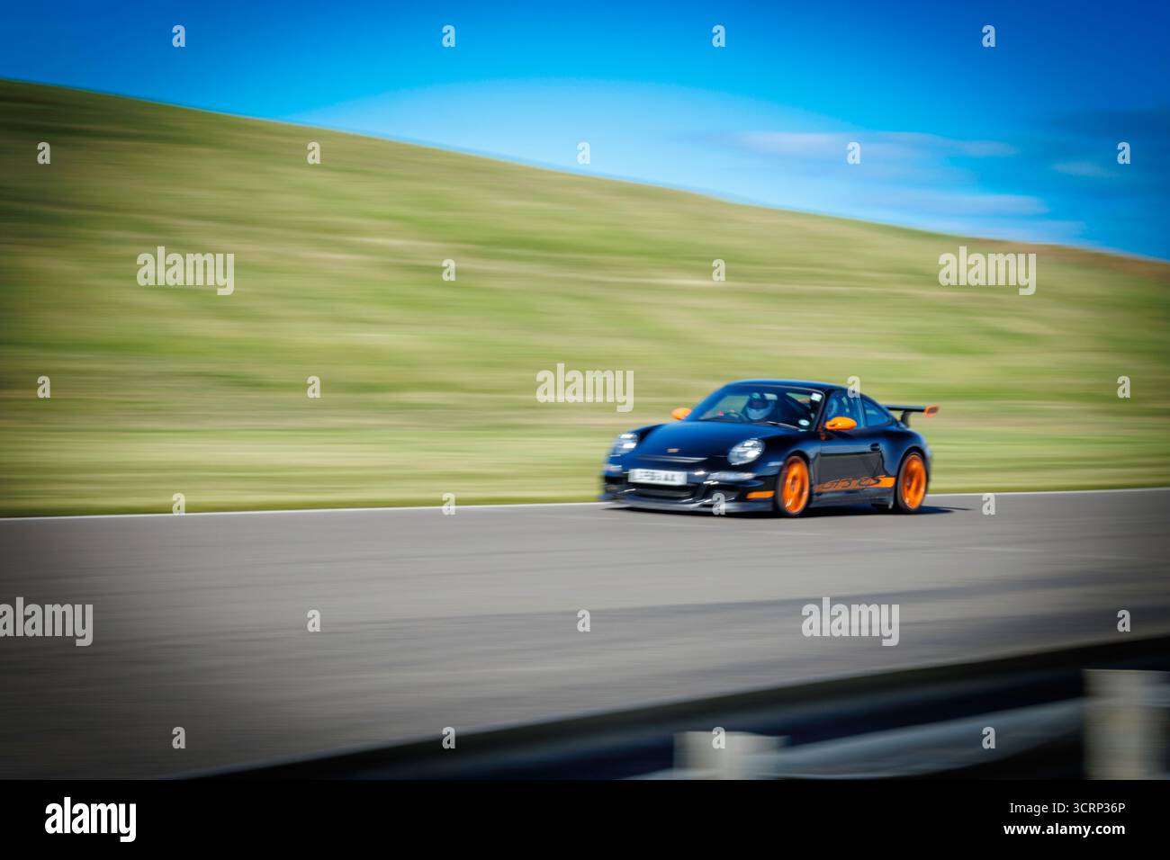 Schwarz-orange Porsche GT3 RS auf der Rennstrecke von Anglesey während des Mission Motorsport Trackday, dem sonnigen britischen Motorsport Hochleistungsevent im September Stockfoto
