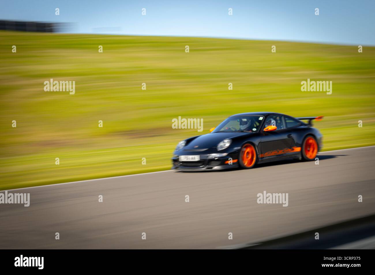 Schwarz-orange Porsche GT3 RS auf der Rennstrecke von Anglesey während des Mission Motorsport Trackday, dem sonnigen britischen Motorsport Hochleistungsevent im September Stockfoto