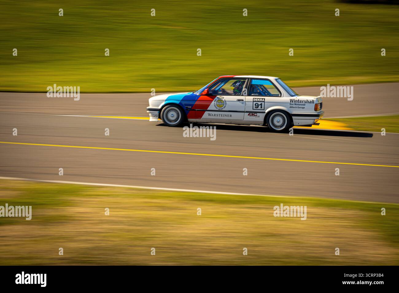 Klassischer BMW 318 in kultiger hellblauer, dunkelblauer und rot gestreifter Lackierung auf der Rennstrecke von Anglesey während des Mission Motorsport Track Day, UK Motorsport Stockfoto