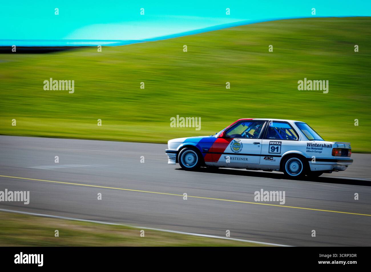 Klassischer BMW 318 in kultiger hellblauer, dunkelblauer und rot gestreifter Lackierung auf der Rennstrecke von Anglesey während des Mission Motorsport Track Day, UK Motorsport Stockfoto