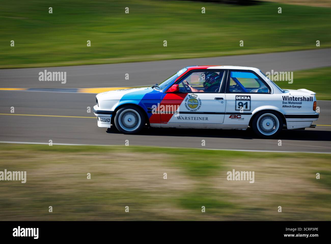 Klassischer BMW 318 in kultiger hellblauer, dunkelblauer und rot gestreifter Lackierung auf der Rennstrecke von Anglesey während des Mission Motorsport Track Day, UK Motorsport Stockfoto