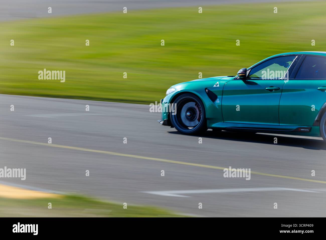 Grüner Alfa Romeo Sportwagen auf der Rennstrecke von Anglesey während des Mission Motorsport Trackday, dem sonnigen britischen Motorsport-Event im September, bei dem Geschwindigkeit und Stil gezeigt werden Stockfoto