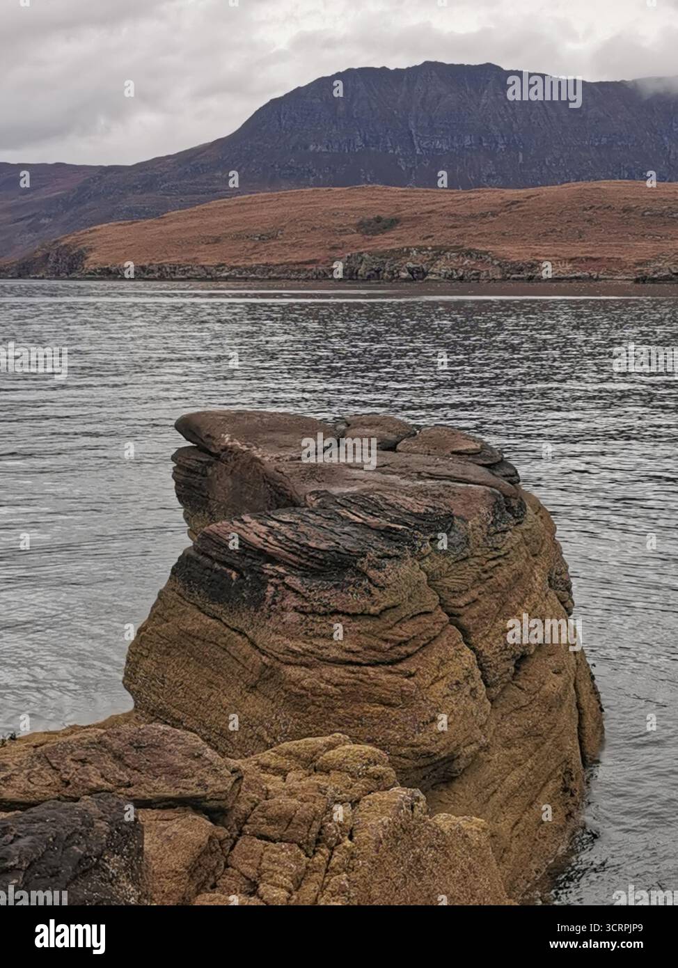 Giant’s Footprint Rock in der Nähe des Rhue Lighthouse, Ullapool. Eine natürliche Kuriosität, die in den Sandstein von Torridonian geschnitten wurde, und ein Anblick an der Nordküste 500. - Smartphone-aufgenommenes Stockfoto