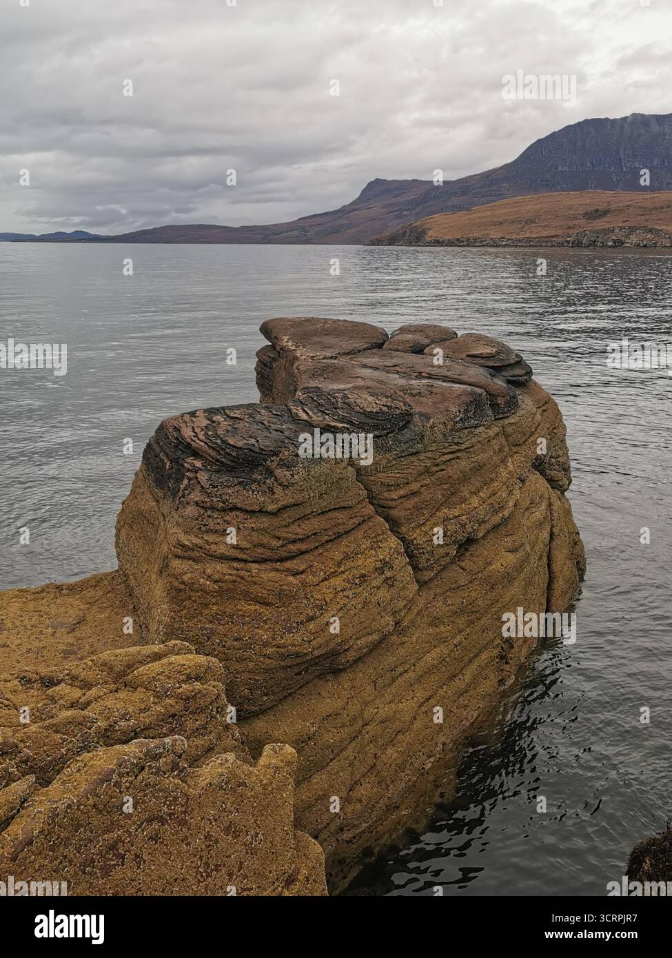 Giant’s Footprint Rock in der Nähe des Rhue Lighthouse, Ullapool. Eine natürliche Kuriosität, die in den Sandstein von Torridonian geschnitten wurde, und ein Anblick an der Nordküste 500. - Smartphone-aufgenommenes Stockfoto