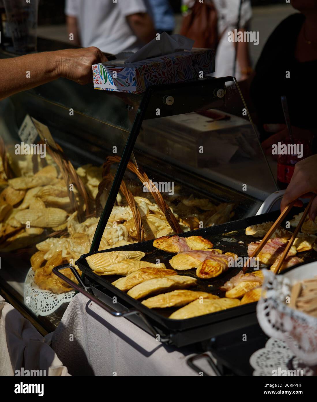 Street Food. Einen Zähler zum Absetzen. Ein Wooman nimmt ein Fladenbrot. Daugh Fladenbrot auf einem Backblech. Marktplatz. Krakau, Polen, Rynek Glowny. Stockfoto