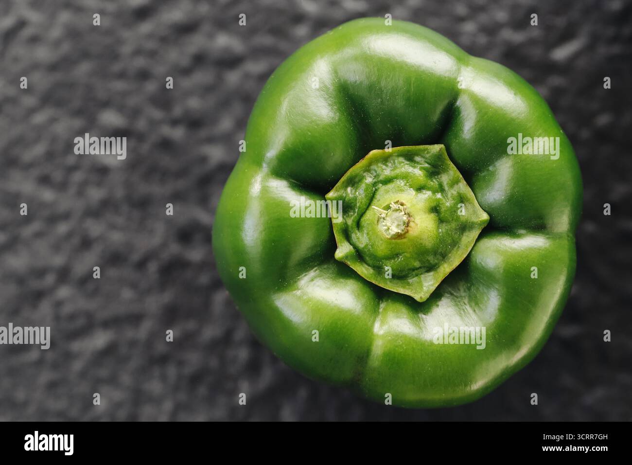 Grüne Paprika-Nahaufnahme auf dunklem Hintergrund. Makrofoto für frisches Gemüse mit natürlicher Textur. Gesunde Ernährung und Bio-Lebensmittelkonzept. Stockfoto
