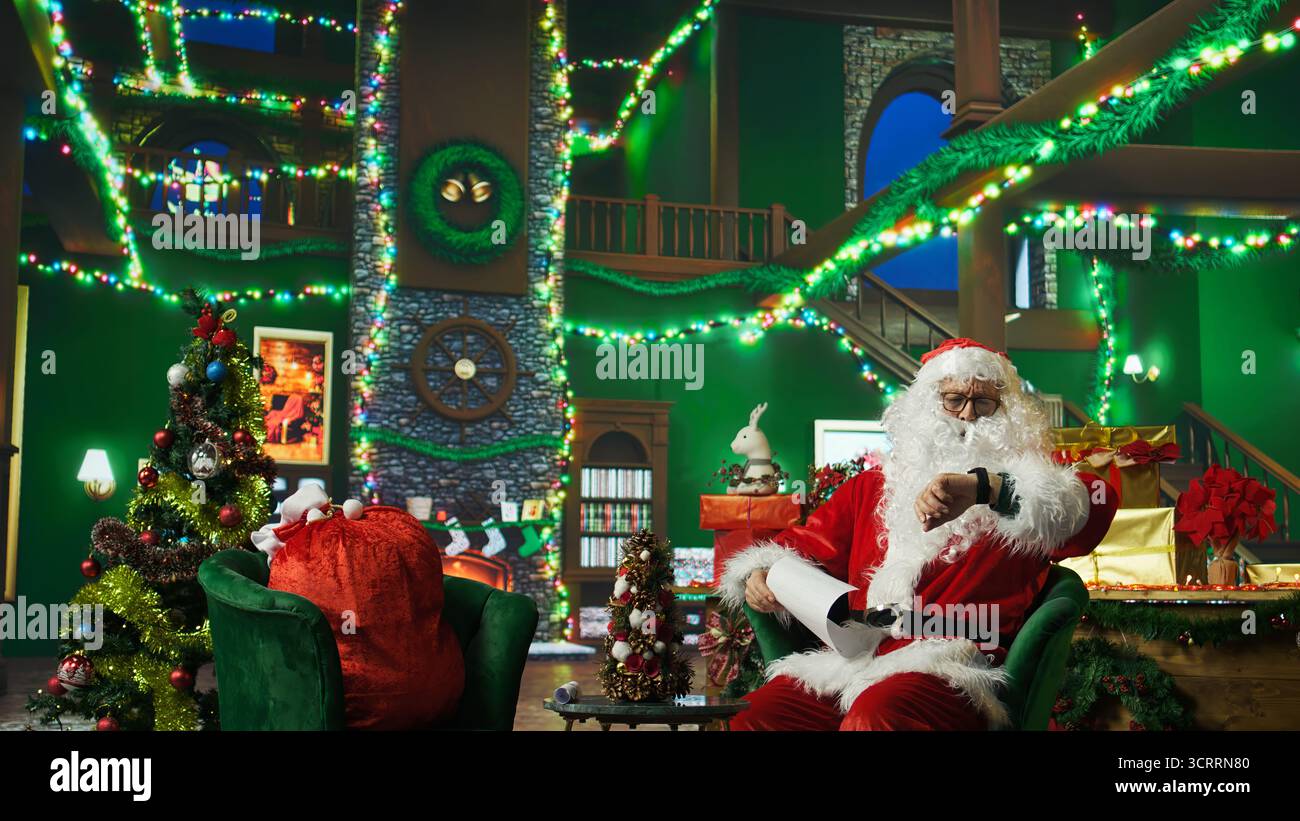 Die Person im Weihnachtskostüm wurde alarmiert, nachdem sie eindöst und spät dran war, Geschenke an Kinder zu liefern. Der Weihnachtsmann wacht auf, nachdem er auf dem Sessel eingeschlafen ist, während er Briefe von Kindern liest, Kamera A Stockfoto