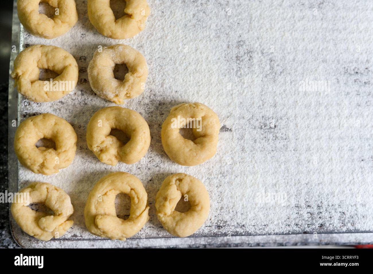 Hausgemachte Donuts auf bemehltem Tablett bereit zum Kochen Stockfoto