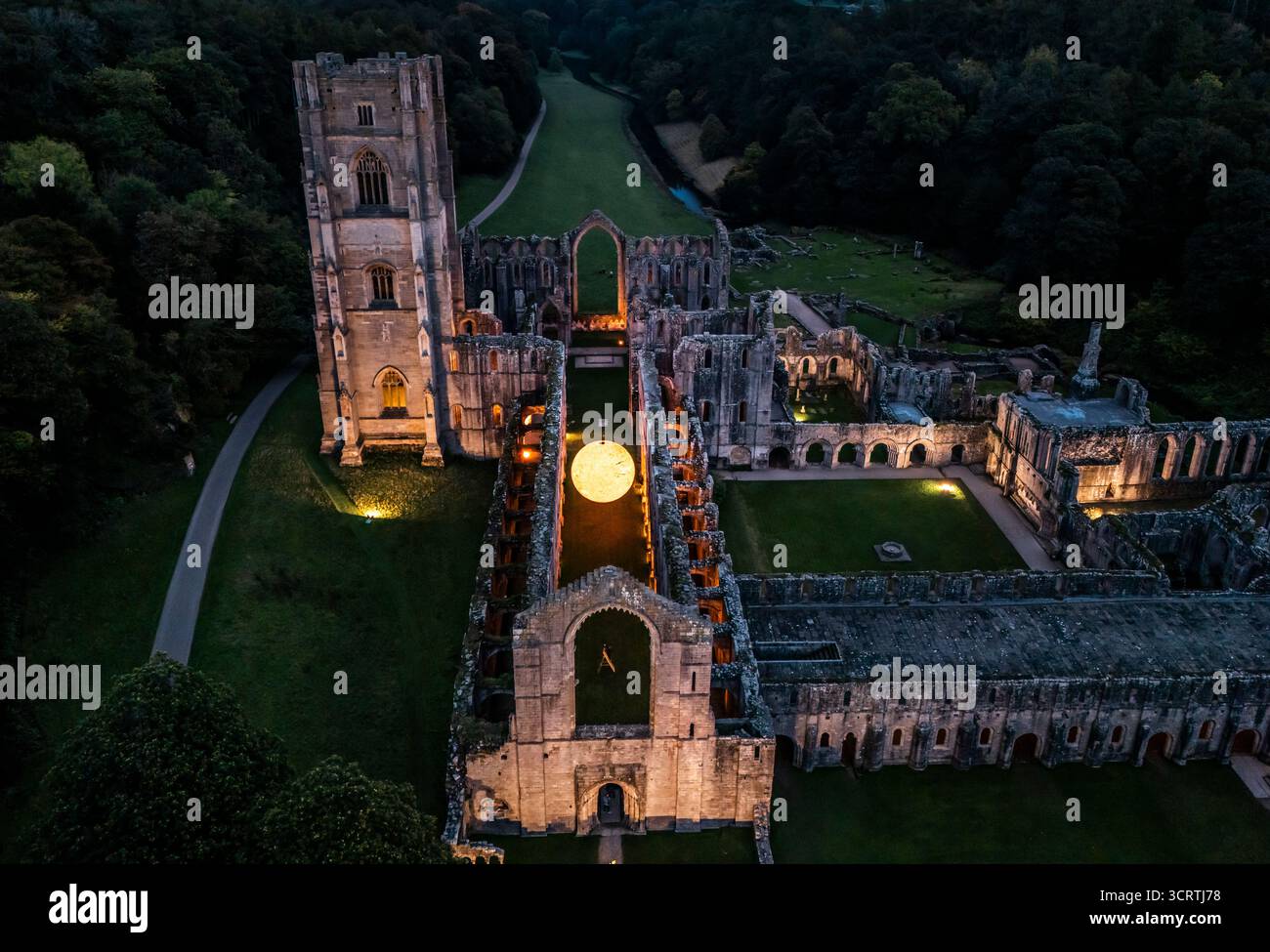 Helios, eine sieben Meter hohe Sonnenskulptur und Soundlandschaft von Luke Jerram, hängt im Schiff der beleuchteten Abteiruinen der Fountains Abbey in der Nähe von Aldfield, Ripon in North Yorkshire. Bilddatum: Donnerstag, 2. Oktober 2025. Stockfoto