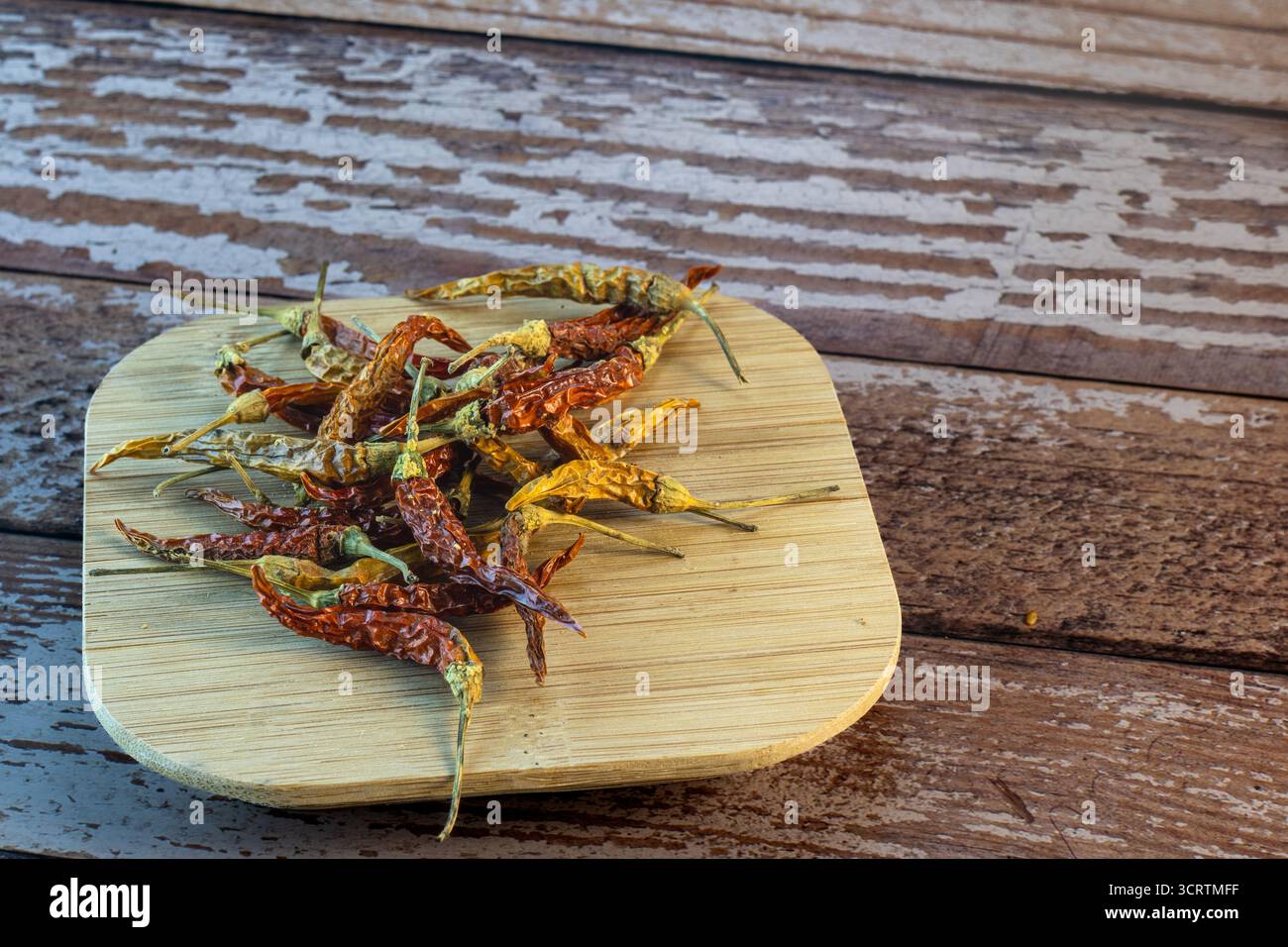 Getrocknete Chilischoten auf rustikalem Holzteller Stockfoto