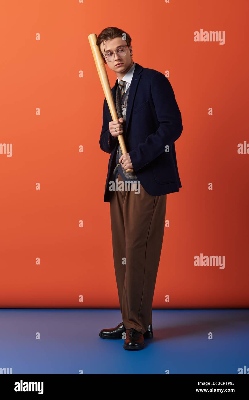 Ein junger Mann mit Baseballschläger verkörpert die moderne Jugendkultur in einer hellen Umgebung. Stockfoto