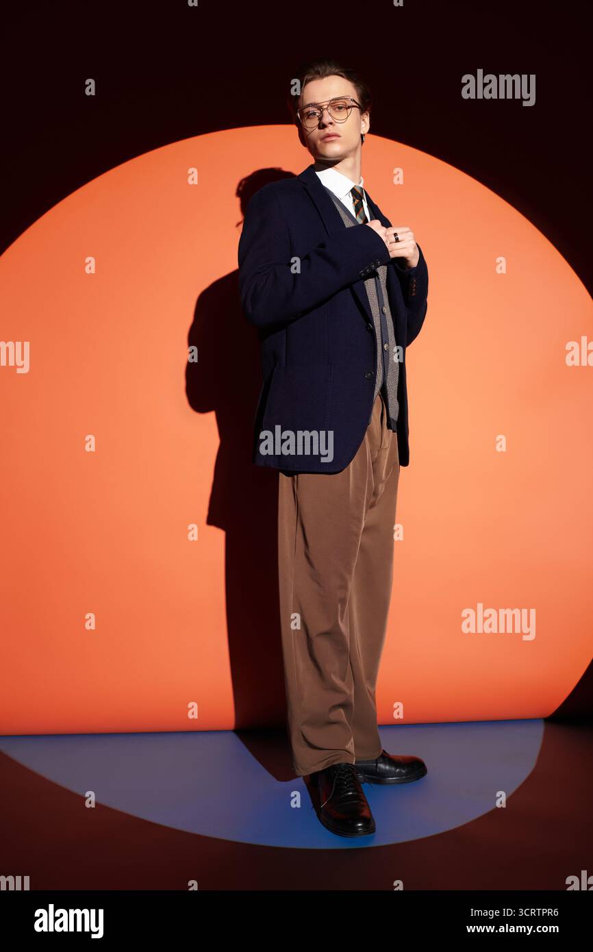 Ein angesagter Teenager steht hoch vor einem lebendigen Hintergrund und zeigt die Jugendkultur. Stockfoto