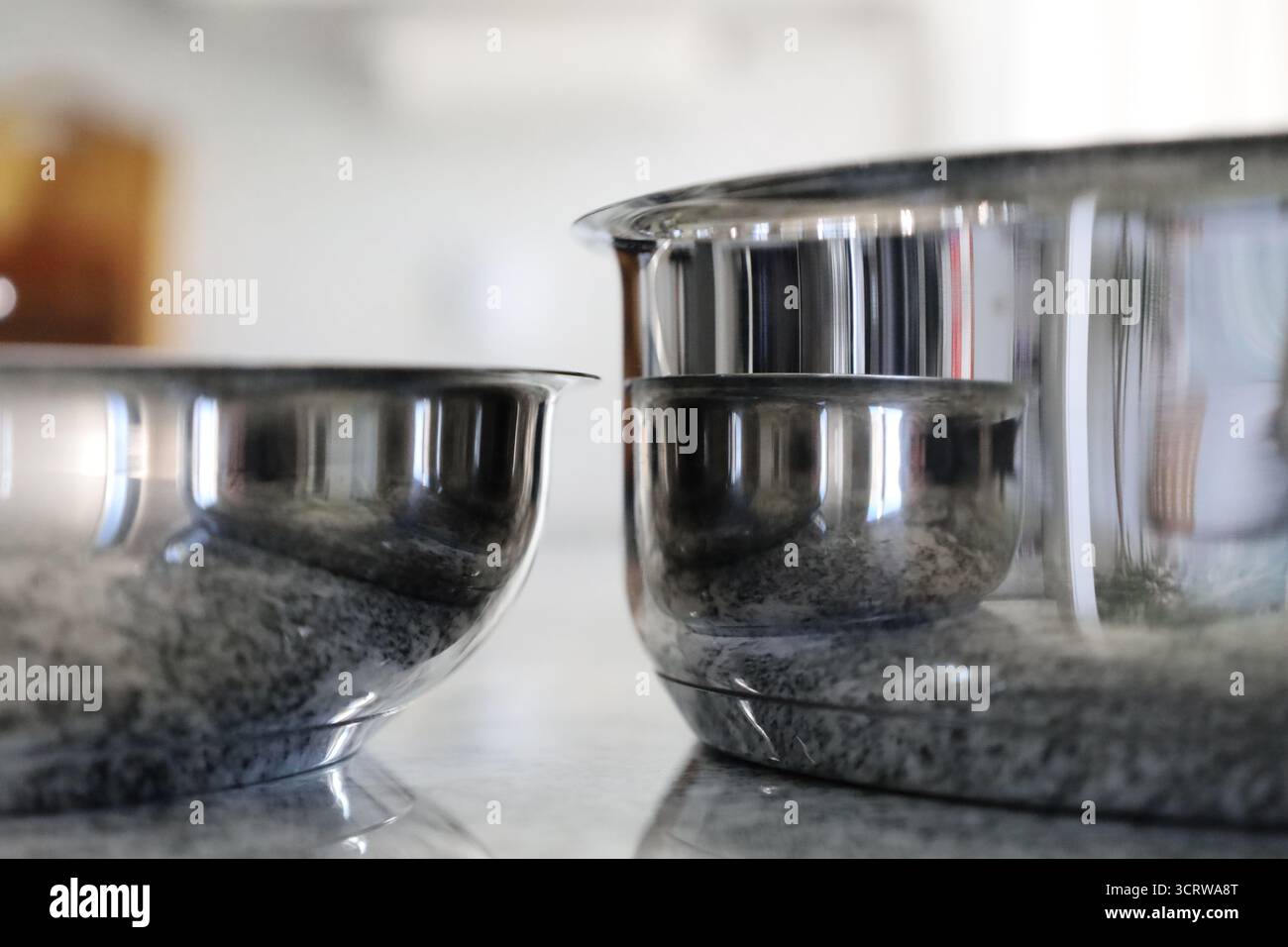 Zwei Edelstahlskillets auf Granit-Küchenarbeitsplatte Stockfoto