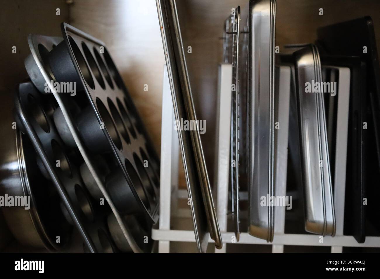 Bettpfannen und Muffinpfannen im Küchenschrank Stockfoto