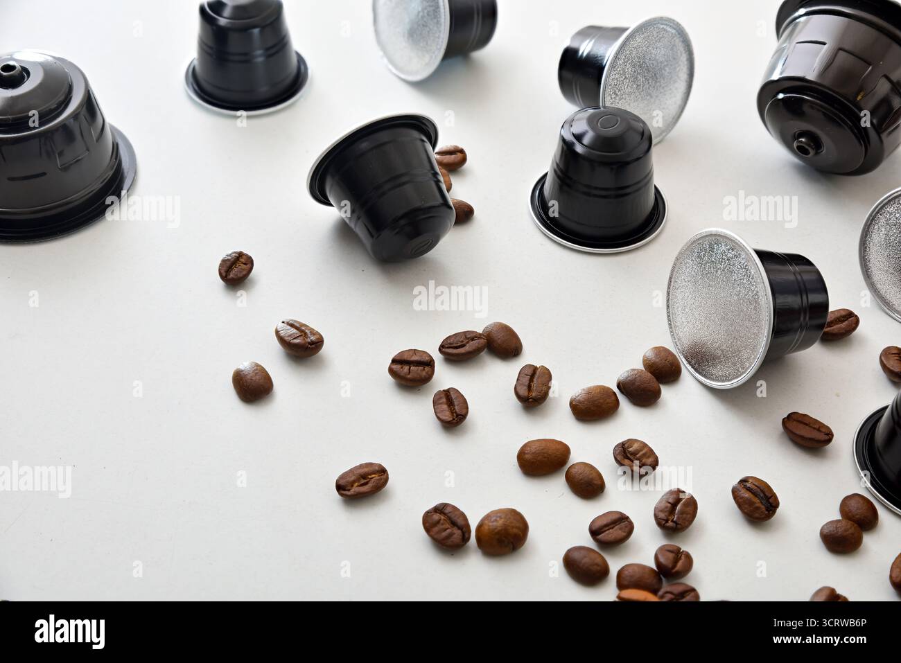 Details verschiedener schwarzer Espresso-Kapseln auf weißem Tisch. Erhöhte Aussicht. Stockfoto