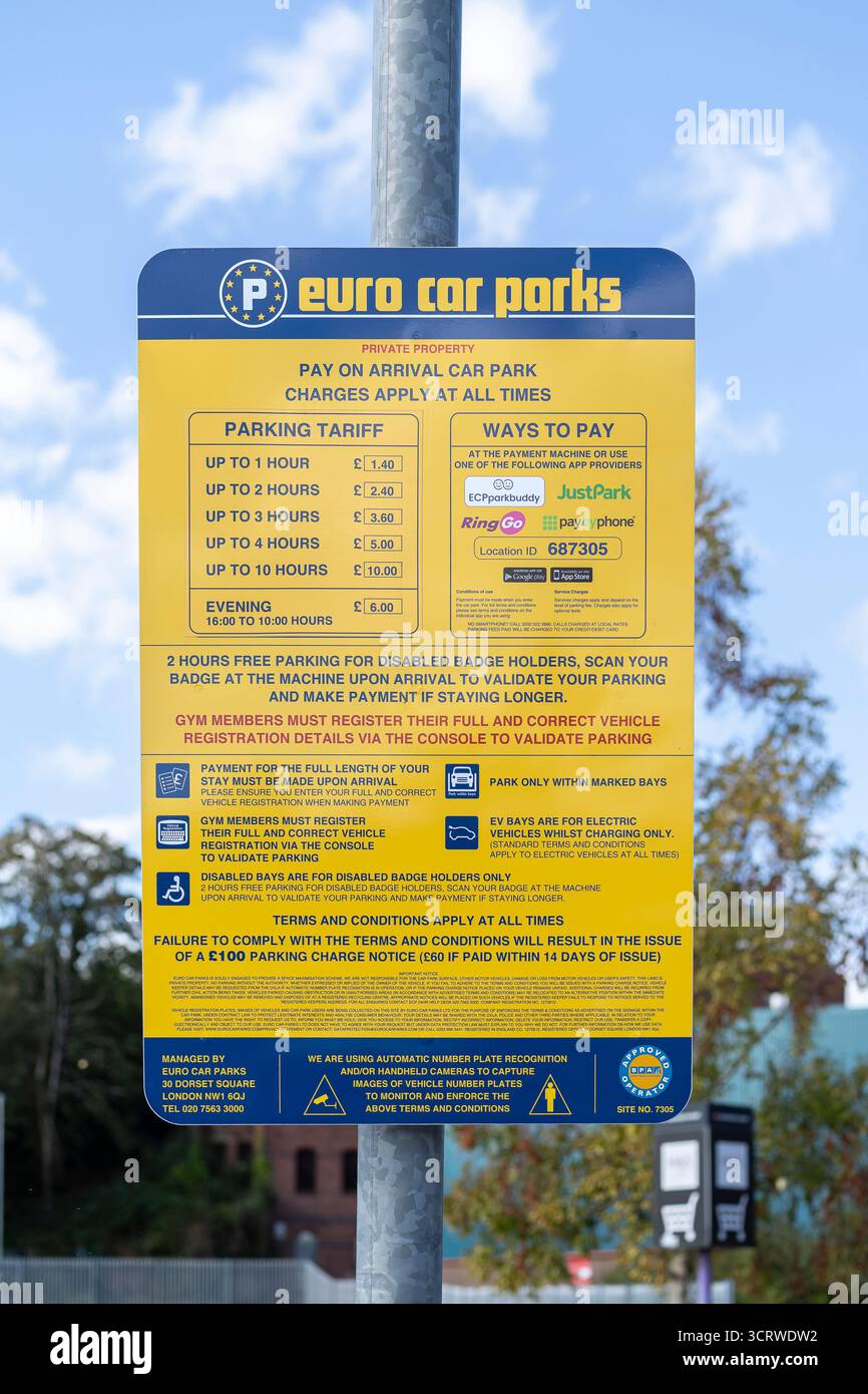 Nahaufnahme eines gelben und blauen Euro-Parkplatzschilds mit Parktarif und Zahlungsmöglichkeiten. Stockfoto