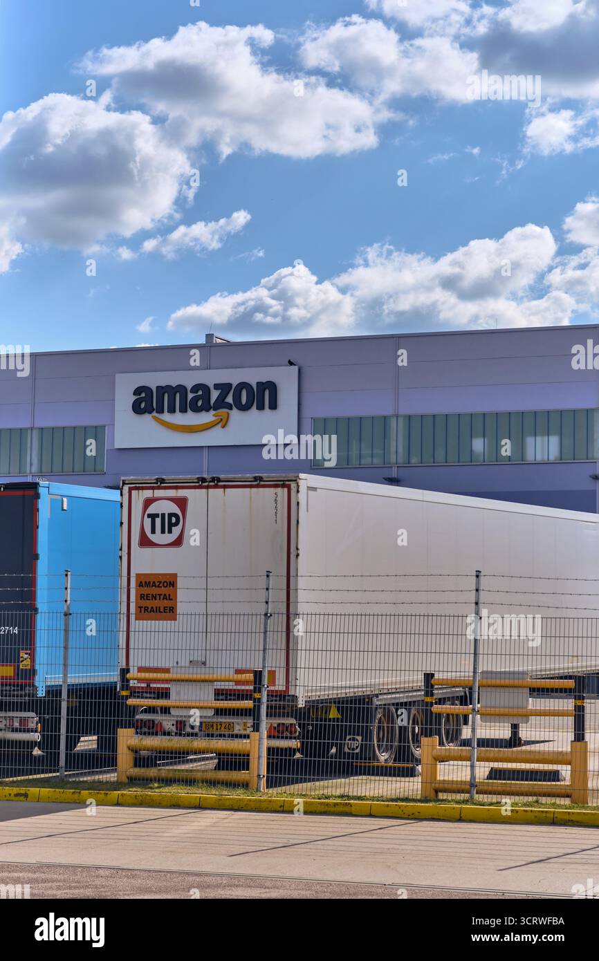 Winsen, Deutschland; 30. September 2025: Amazon-Vertriebszentrum mit Mietwagen vor einem modernen Lager im Rahmen der E-Commerce-Logistik und Stockfoto