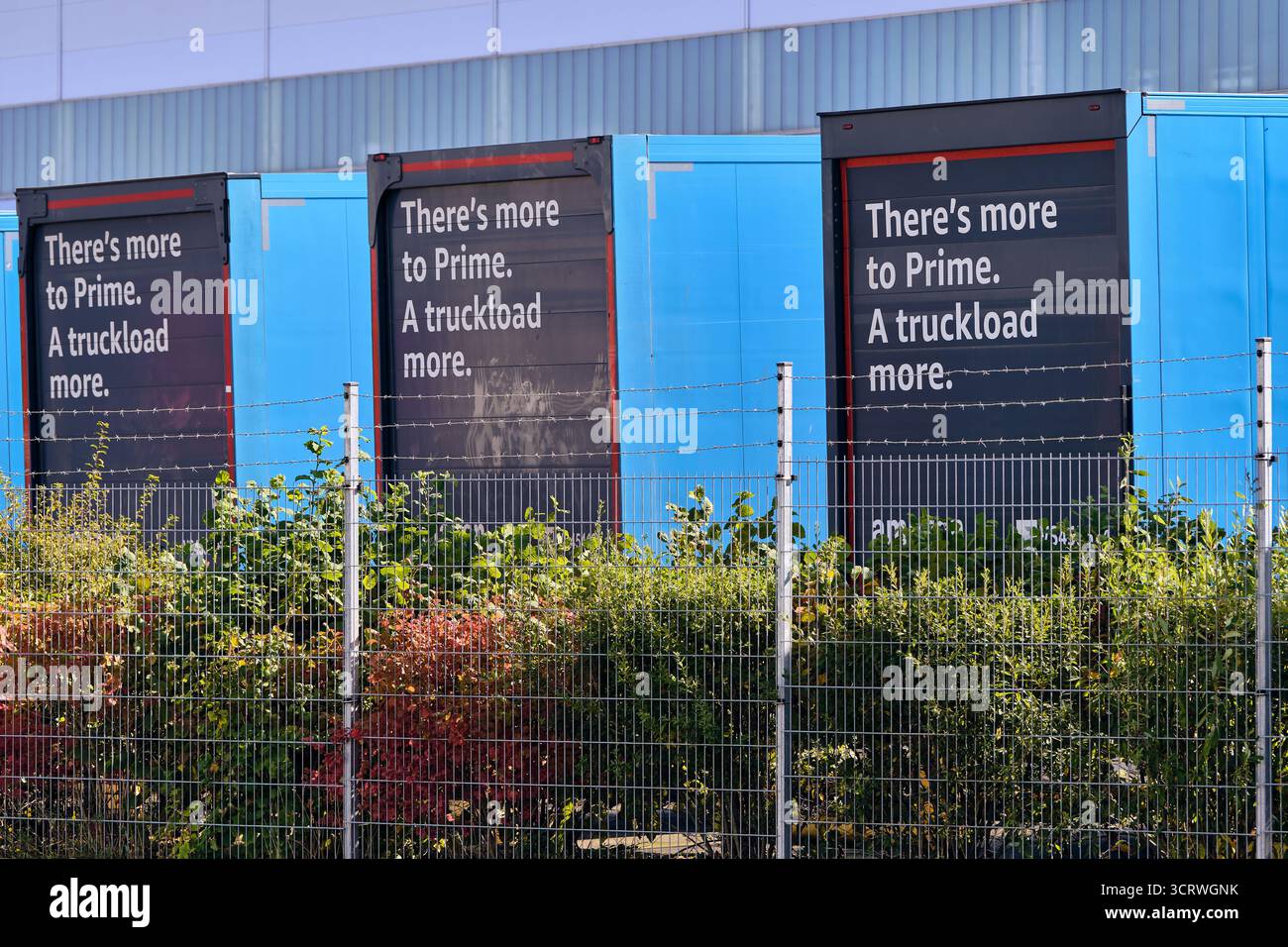Winsen, Deutschland; 30. September 2025: Drei Anhänger der Marke Amazon Prime mit einem Slogan, der im Vertriebszentrum geparkt ist und die E-Commerce-Logistik symbolisiert, Stockfoto