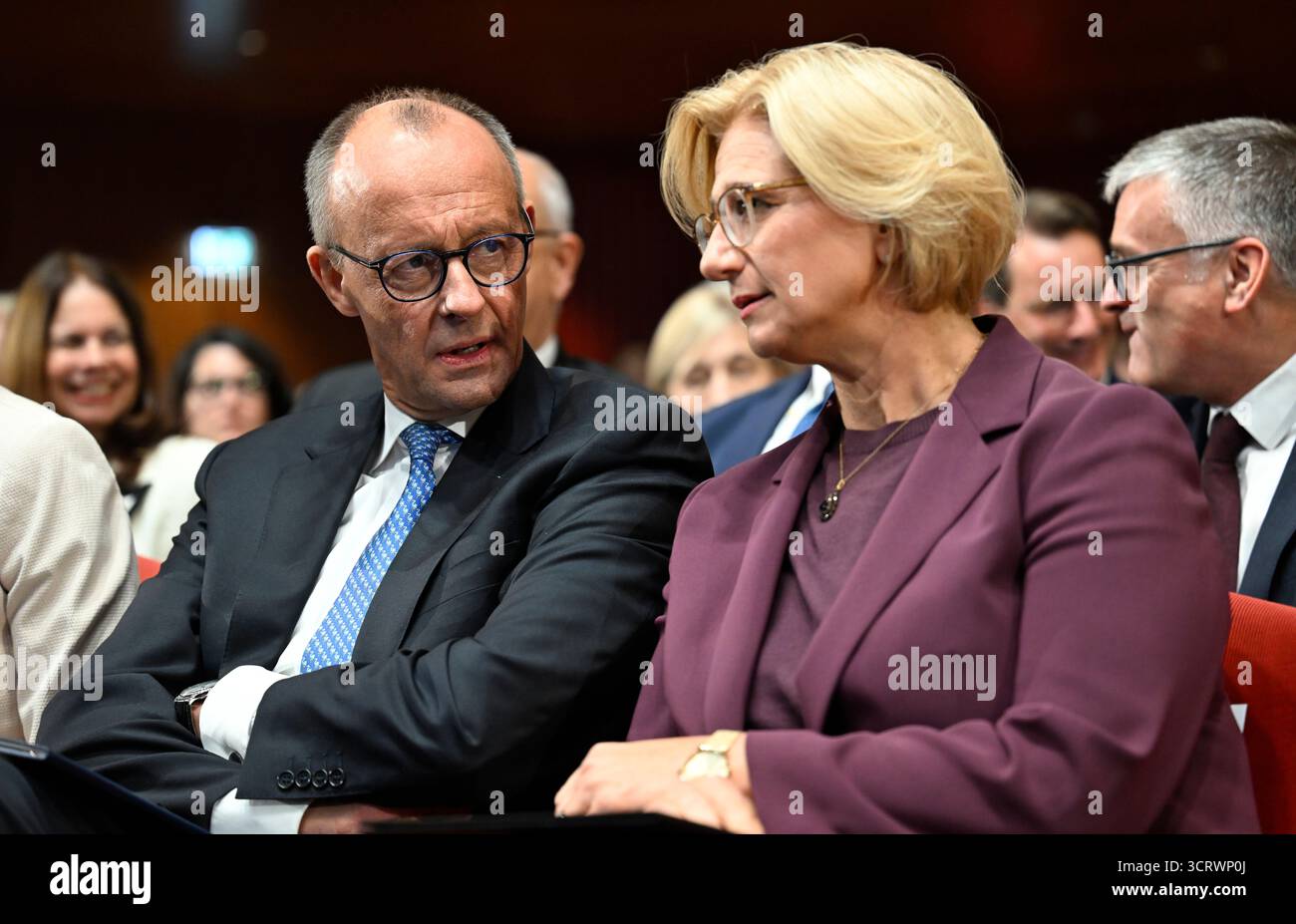 03. Oktober 2025, Saarland, Saarbrücken: Bundeskanzler Friedrich Merz (CDU) spricht mit Saarlandministerpräsidentin Anke Rehlinger (SPD) bei den zentralen Feierlichkeiten zum Tag der Deutschen Einheit im Kongresssaal. Am 3. Oktober 2025 feiert Deutschland den 35. Jahrestag der deutschen Wiedervereinigung. Foto: Jean-Christophe Verhaegen/POOL AFP/dpa Stockfoto