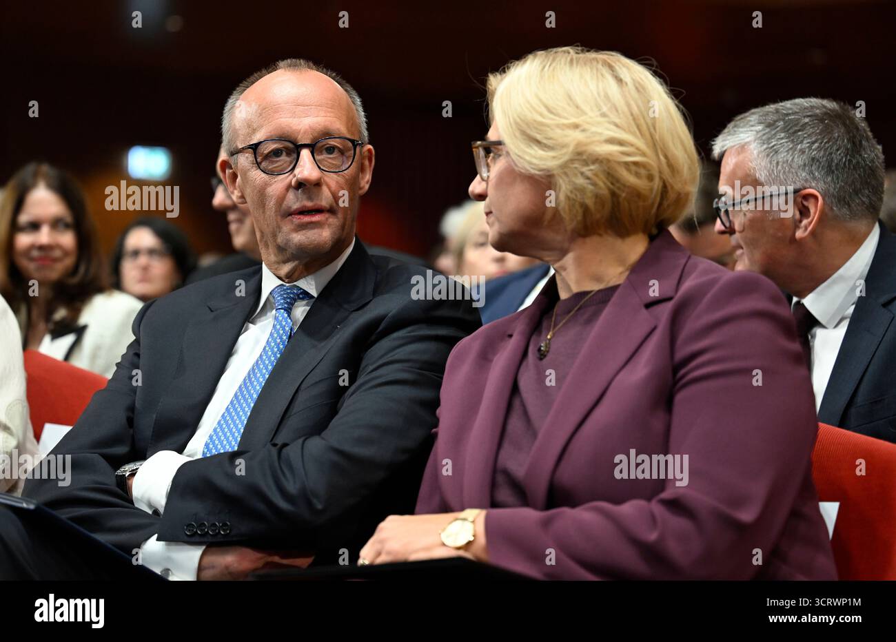 03. Oktober 2025, Saarland, Saarbrücken: Bundeskanzler Friedrich Merz (CDU) spricht mit Saarlandministerpräsidentin Anke Rehlinger (SPD) bei den zentralen Feierlichkeiten zum Tag der Deutschen Einheit im Kongresssaal. Am 3. Oktober 2025 feiert Deutschland den 35. Jahrestag der deutschen Wiedervereinigung. Foto: Jean-Christophe Verhaegen/POOL AFP/dpa Stockfoto
