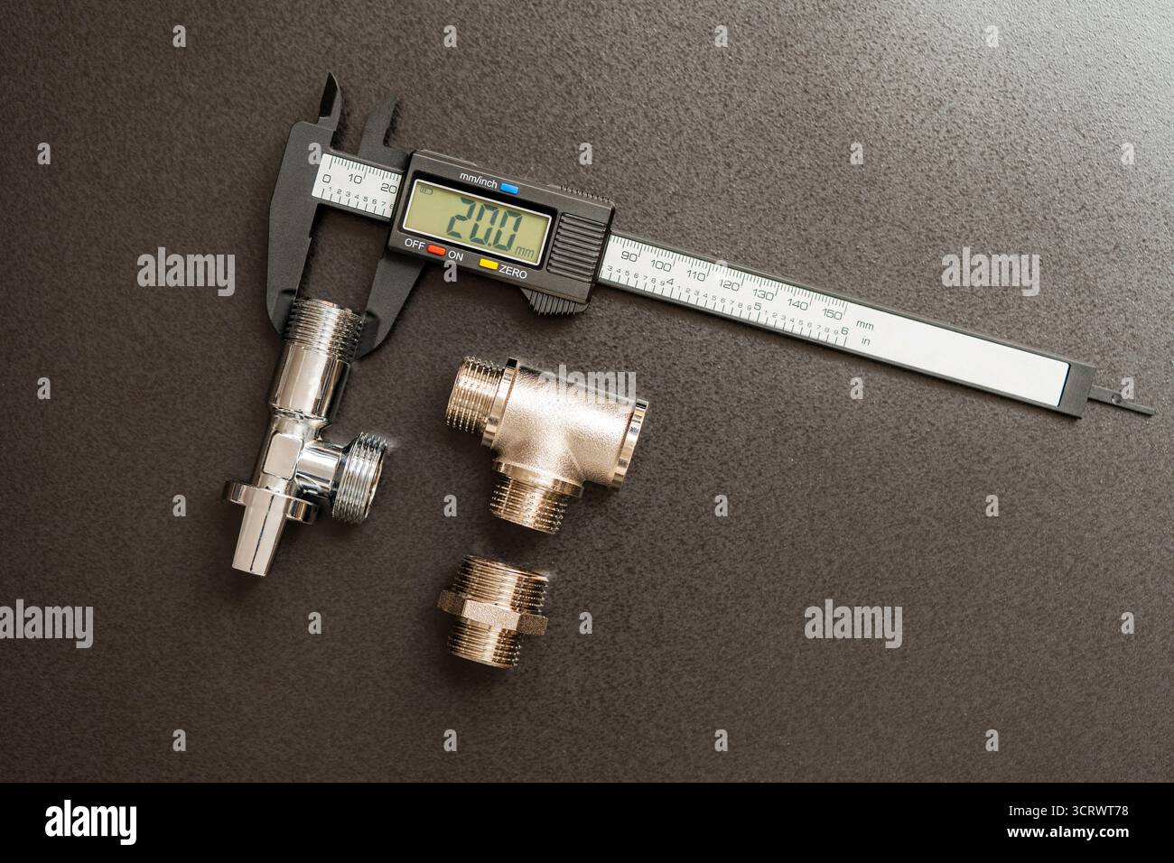 Messung des Durchmessers von Rohrleitungsadaptern mit einem elektronischen digitalen Messschieber, Nahaufnahme, Draufsicht. Sanierungskonzept für Sanitär Stockfoto