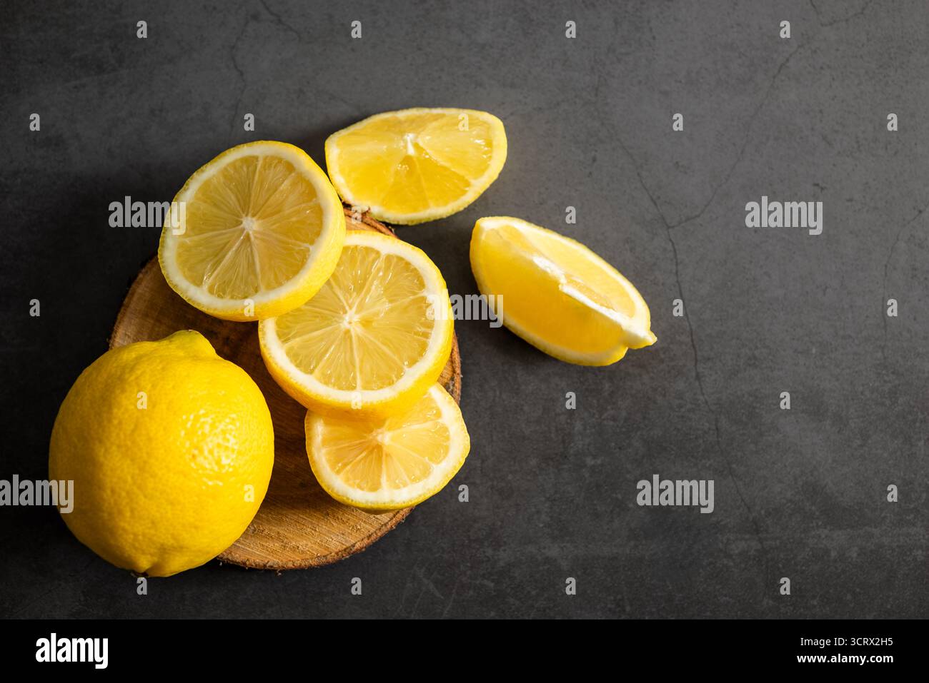 Zitrone mit Schnitten, Draufsicht auf dunklem Hintergrund. Stockfoto