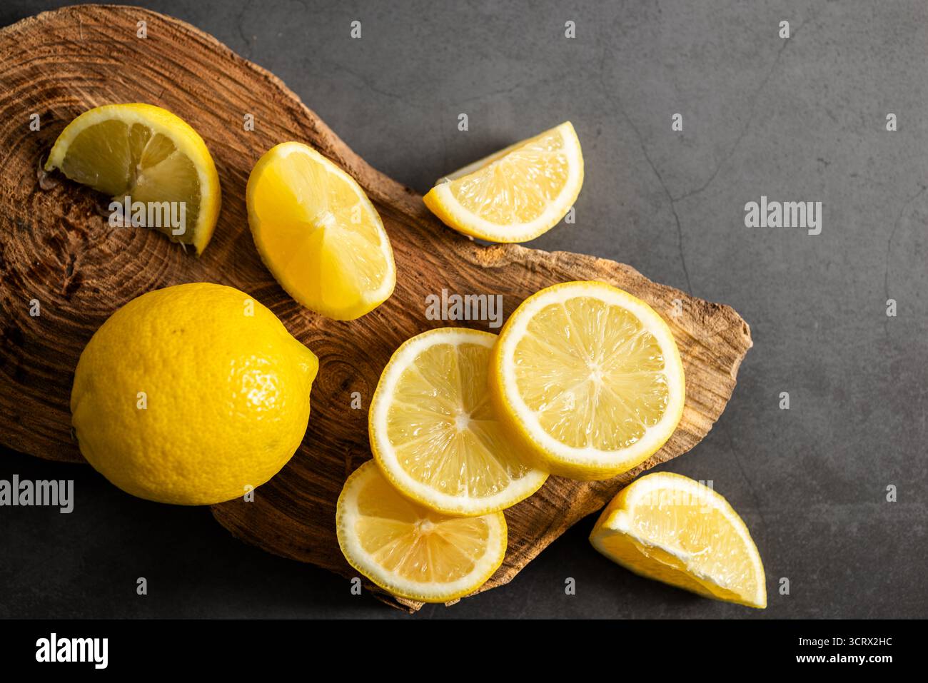 Zitrone mit Schnitten, Draufsicht auf dunklem Hintergrund. Stockfoto